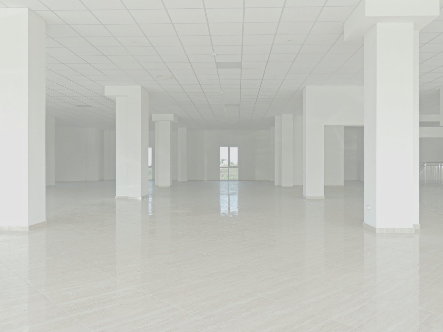 Unfurnished commercial space with white columns and tiled floor.