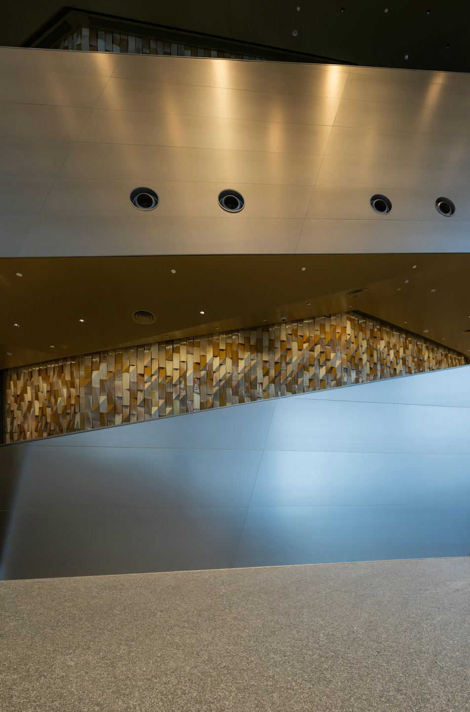 Modern interior wall features geometric panels above a speckled floor.