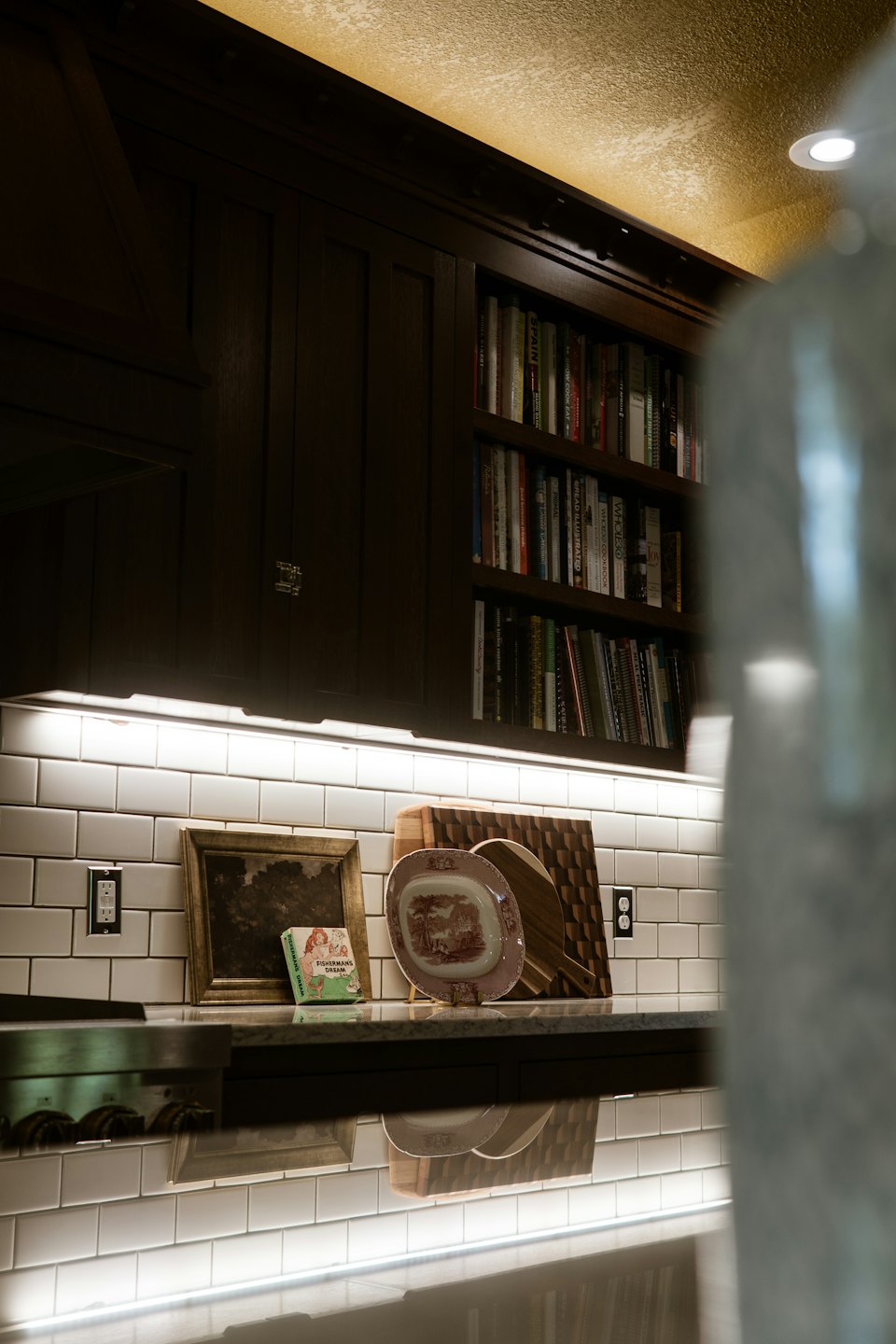 Kitchen counter displaying wooden boards, ceramic plate, and cookbooks.