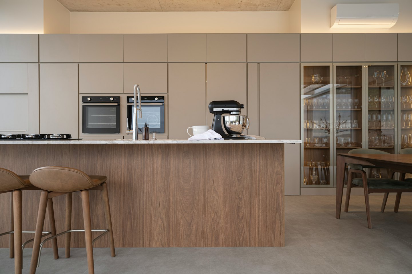 Modern kitchen island with marble countertop and bar stools.